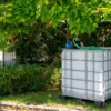 ibc-container-wit-met-pomp-220V-1000L-gereinigd-pallet-metaal-of-kunststof-rechteraanzicht-in-tuinomgeving.webp