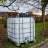 ibc-container-wit-met-pomp-accu-1000L-gereinigd-pallet-metaal-of-kunststof-linkerzijaanzicht-tuinomgeving-zonder-slang.webp